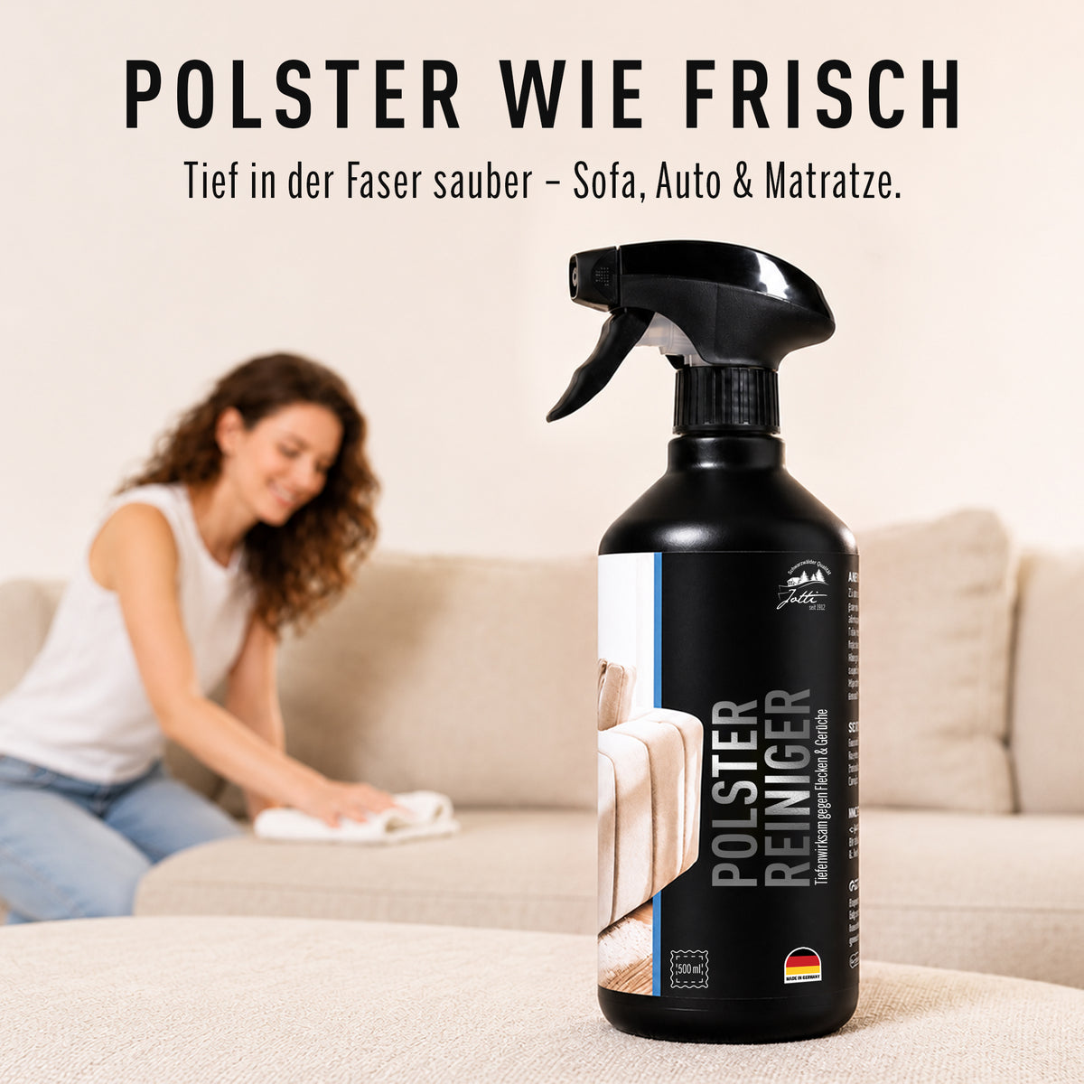 Polsterreiniger wird mit einem Tuch in ein helles Sofa eingearbeitet